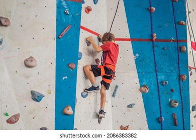 Boy at the climbing wall without a helmet, danger at the climbing wall - Powered by Shutterstock