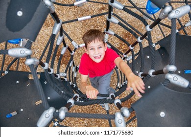 boy climbs up the Jungle Gym. the child having fun on outdoor playground. top view - Powered by Shutterstock