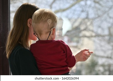 A Boy With Cochlear Implants With His Mother