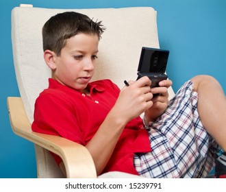 A boy concentrating on the game he is playing on his electronic game device.