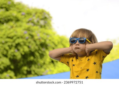 The boy covered his ears with his hands. The child does not want to hear from teachers and parents. The child wants silence, do not yell at children - Shutterstock ID 2369972751
