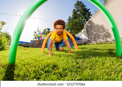 Boy crawl under barriers in a competitive game - Powered by Shutterstock