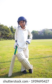 Boy In Cricket Uniform Holding A Cricket Bat 