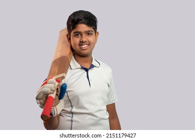 A boy in cricket uniform holding Cricket Bat