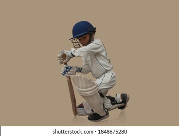 A boy in cricket uniform playing Cricket