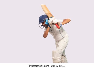 A boy in cricket uniform playing Cricket