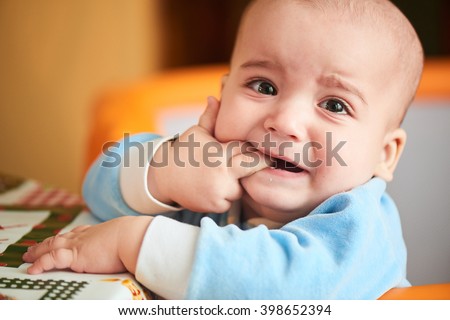 The boy was crying and biting your fingers, climb first teeth