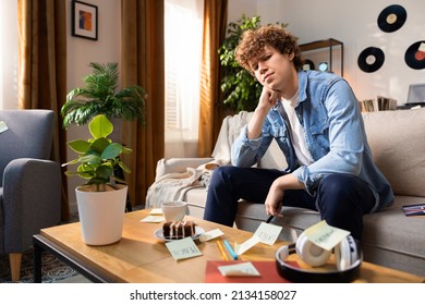 A Boy With Curly Hair Looks Confusedly At A Table Full Of Things. He Tries To Remember All The Words Associated With It.
