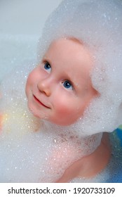 Boy With A Cute Smile. The Child Bathes In A Bubble Bath.