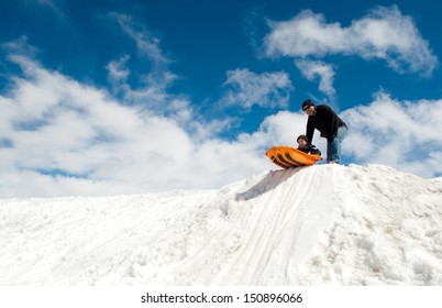 Boy And Dad Sledding In Winter