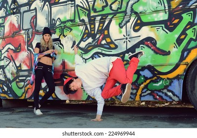 Boy Dancing Break Dance In Front Of A Beautiful Girl With Stylish Bus On The Street