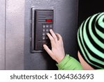 The boy dials the code on the door