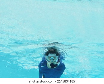 Boy is diving using snorkel in the clean clear sea water