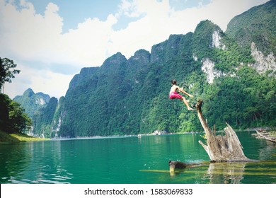 Boy Doing Backflip Into The Water At Khao Sok National Park, Surat Thani Province, Thailand.