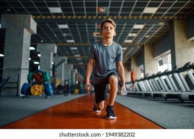 Boy Doing Exercise With Dumbbells In Gym