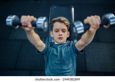 Boy Doing Exercise With Dumbbells On Bench