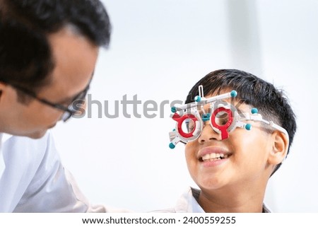 Boy doing an eye test checking examination with optometrist in the optical shop, Smiling Indian-thai boy choosing glasses in an optics store