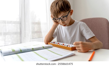 boy doing mental arithmetic on abacus at the table