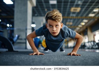 Boy doing push up exercise in gym, front view - Powered by Shutterstock