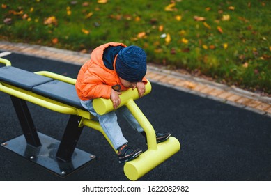 Boy Doing Situps On Exerciser At Park