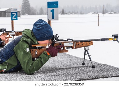 Boy doing target practice with a laser gun for biathlon training in winter