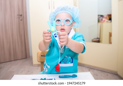 A Boy With Down Syndrome Plays As A Doctor, A Child In A Doctor's Costume, Children With Disabilities.
