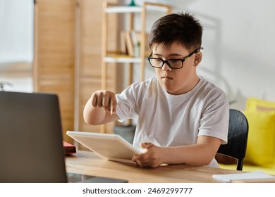 Boy with Down syndrome using tablet computer, wearing glasses.