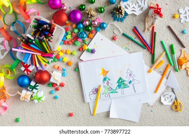 A Boy Draws A Christmas Tree. Child's Drawing Christmas. The Child Lies On The Floor And Draws In A Notebook With White Paper.