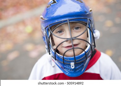 A Boy Dressed To Be The Goalie In A Street Hockey Game