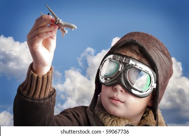 Boy Dressed Up In Pilot?s Outfit, Jacket, Hat And Glasses.