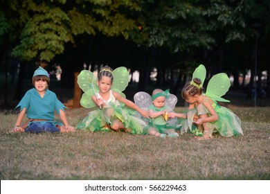 Boy dressed as Peter Pan, two girls and baby in fairy costume. Fairies