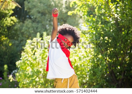 Boy dressed as a super hero in a park on a sunny day