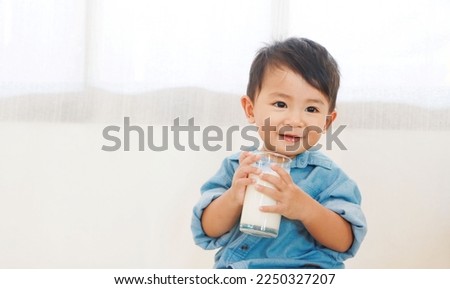 Boy drinking milk from glass And smiling happily, under the concept of drinking milk for good health.