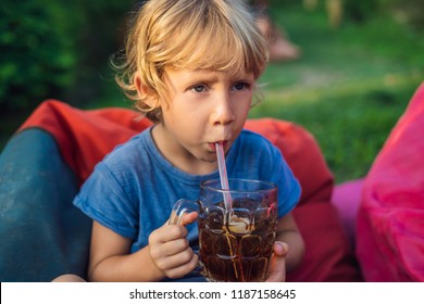 Boy Drinks A Litchi Drink In Outdoor Cafe