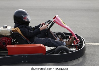 boy is driving Go-kart car with speed in a playground racing track. Go kart is a popular leisure motor sports. - Shutterstock ID 400812958