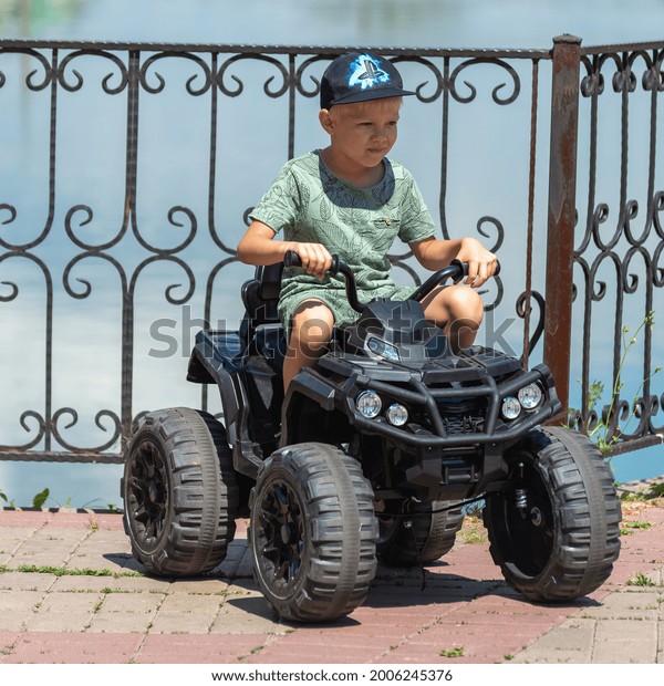The boy is driving a small car in the park.\
Russia, Salavat. 03.07.2021