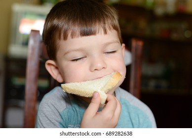 Boy Eating Bread With Cream Cheese Toast. Child Eats Sandwich With Cream Cheese For Breakfast