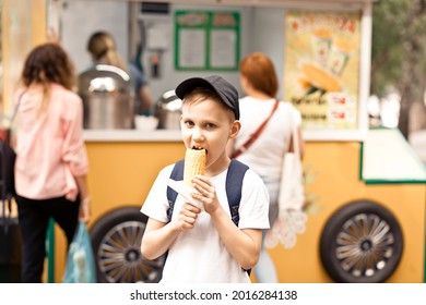Boy eating fresh boiled corn on street market food track