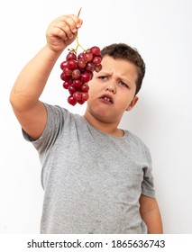 Boy Eating Grapes On A Light Background