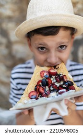 Boy Eating Healthy Fruit Pizza In The Old Town Of Budva, Montenegro.