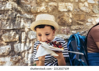 Boy Eating Healthy Fruit Pizza In The Old Town Of Budva, Montenegro.