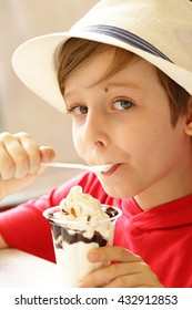 boy eating ice cream with chocolate syrup