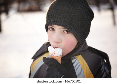 Boy Eating An Ice Cream On Snow Background