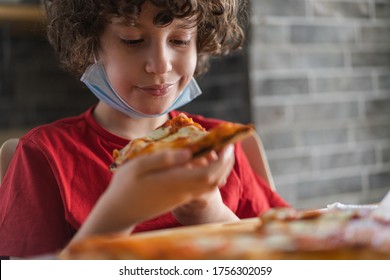 Boy Eating Pizza On A Restaurant During Coronavirus Pandemic. Reopening Of Food And Drink Activities After The Lockdown.