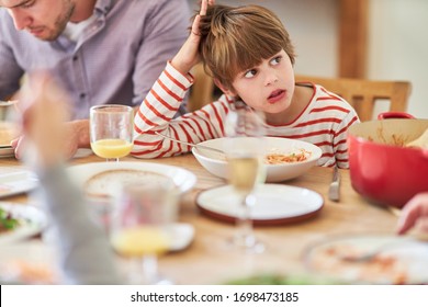 Boy Eating Spaghetti With Family At The Dining Table Is Bored