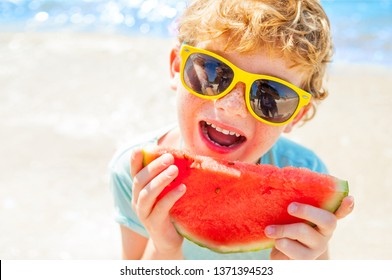 boy eating watermelon on the background of the sea, the beach, the sea coast in the summer during a vacation - Powered by Shutterstock