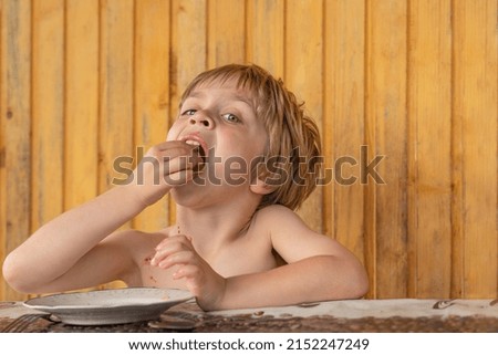 The boy eats something delicious in the summer in the countryside
