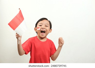 A boy energetically waves Indonesian flags,his mouth open in a shout of excitement.His enthusiasm and patriotic spirit make this image Perfect for Indonesian Independence Day, and national events. - Powered by Shutterstock