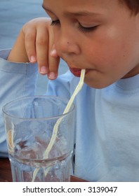 Boy enjoying water with drinking straw