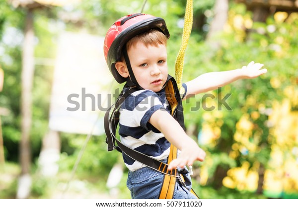 Boy\
enjoys climbing in the ropes course adventure.\
